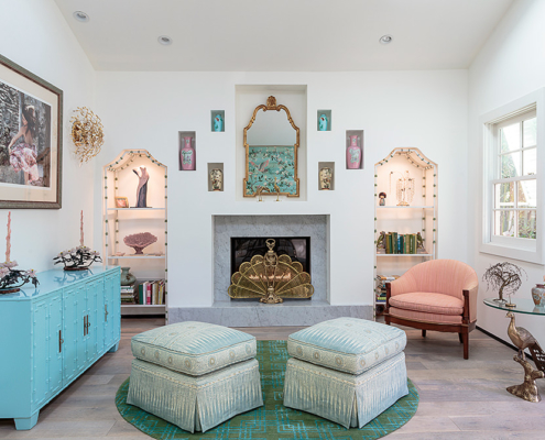 Touch Interiors fireplace reading room featuring peacock table, custom ottomans and built out niche wall for antique vessels