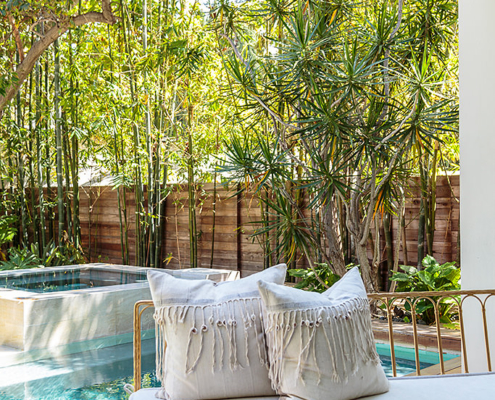 Touch Interiors outdoor sofa with pool and shell pillows