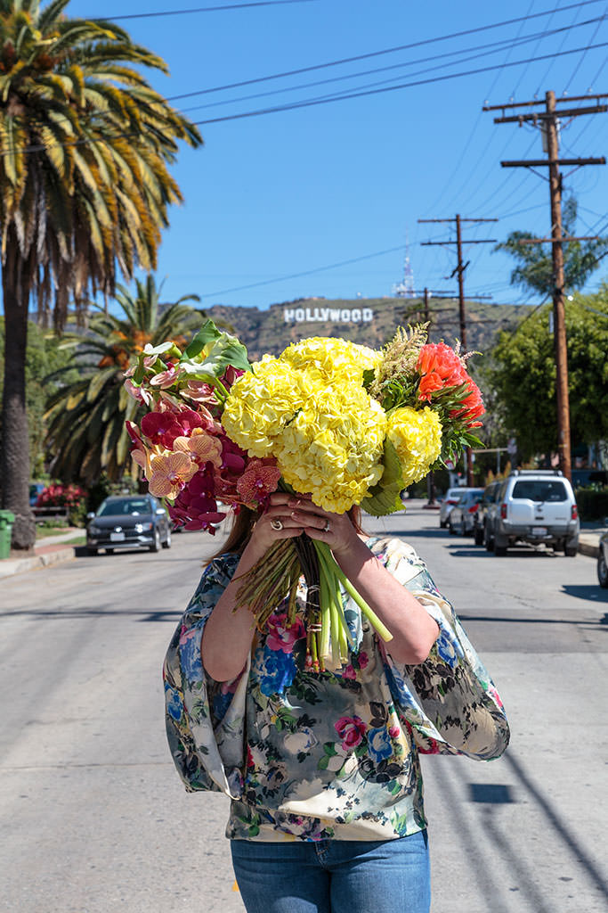Bronwyn holding flowers under the Hollywood sign