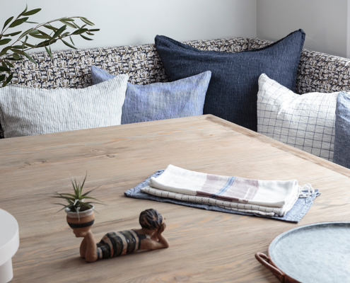 All shades of blue pillows on reclaimed wood table