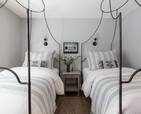 Bed linen with grey and white stripe pillow and blanket, rope wall sconces by Curry and Co.