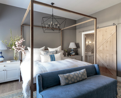 Reclaimed wood four poster bed in bedroom with gray walls