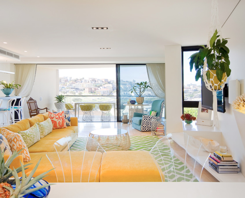 Touch Interiors Yellow sectional and green rug