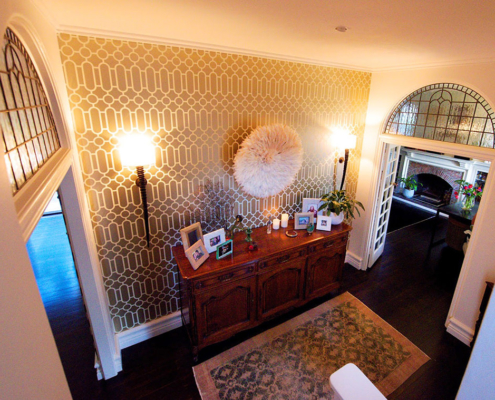 Entry vestibile with antique sideboard and Designer Guild wallpaper