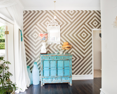 Geometric wallpaper with turquoise sideboard