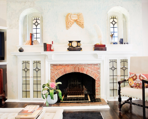 Brick fireplace with lead light windows and cabinet doors